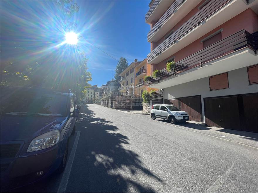 la strada antistante con posti auto